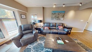 A living room with a sectional sofa, a single armchair, a coffee table, and a rug. - Mt Green 1-f05 (Killington)
