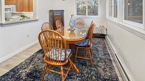 Un coin repas avec une table ronde, des chaises en bois et un lustre.