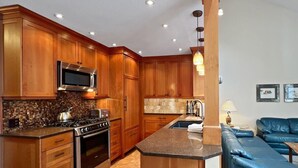 Een moderne keuken met houten kastjes, roestvrijstalen apparatuur en een centraal eiland.