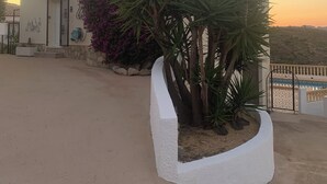 A white building with a satellite dish, a door, and a window. There is a white planter with plants and a white wall. - Mountain villa + sea view. Privacy, tranquillity. Near Javéa, Moraira and Dénia (VC)