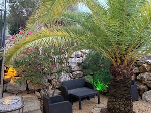 Relax in a serene garden setting surrounded by lush greenery and vibrant flowers.