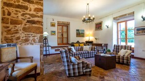 Ein geräumiges Wohnzimmer mit Steinwand, Holzboden und Karomöbeln.