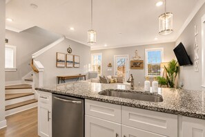 A modern kitchen with granite countertops, stainless steel appliances, and pendant lighting. - NEW! Lakeside Blues: Rooftop / Marina / Family Fun (Nashville)