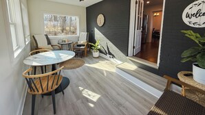 A cozy room with a dining table, chairs, a ceiling fan, and a large window. - Pony Creek Cottage (North Manchester)