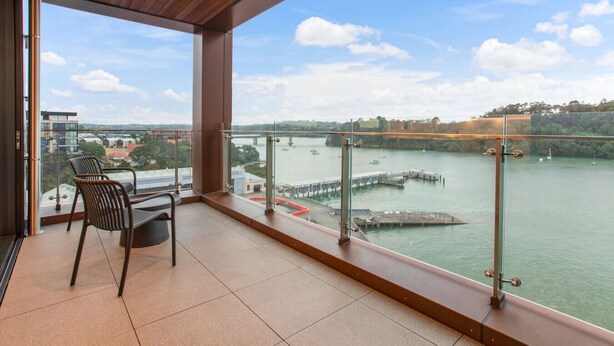 A balcony with a view of a river, a bridge, and a cityscape. - Gorgeous Home with Catalina Bay Views and Carpark (Auckland West)