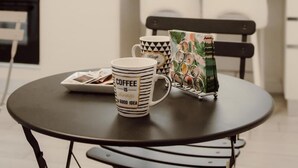 Eine moderne Küche mit weißen Schränken, einer Mikrowelle und einem Couchtisch mit Tassen und einem dekorativen Gegenstand.