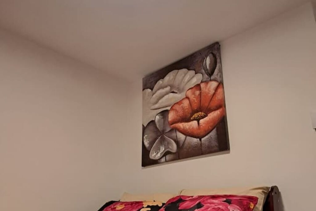 A painting of flowers on a wall in a room.