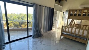 Una habitación amplia con techo alto, ventanas grandes y techo de madera.