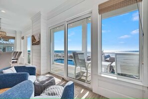 Ein geräumiger Balkon mit Blick auf einen Pool, weiße Wände und moderne Möbel.