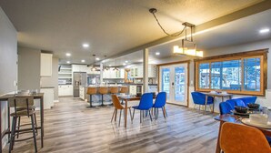 A spacious kitchen with modern appliances and a dining area with blue chairs. - Arabian Nights Suite at Country Way Inn (Kalispell)