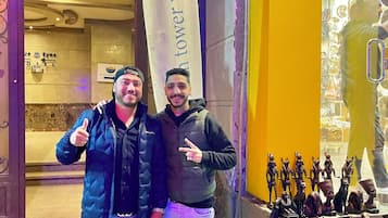 Dos personas frente a un edificio con un cartel que dice "tower view".
