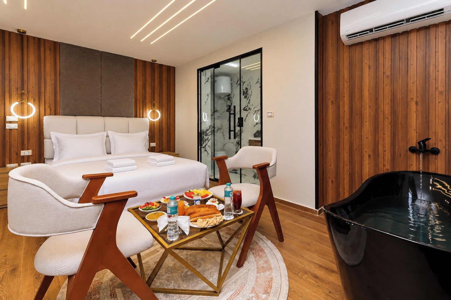 Una habitación de hotel moderna con cama, zona de estar y bañera.