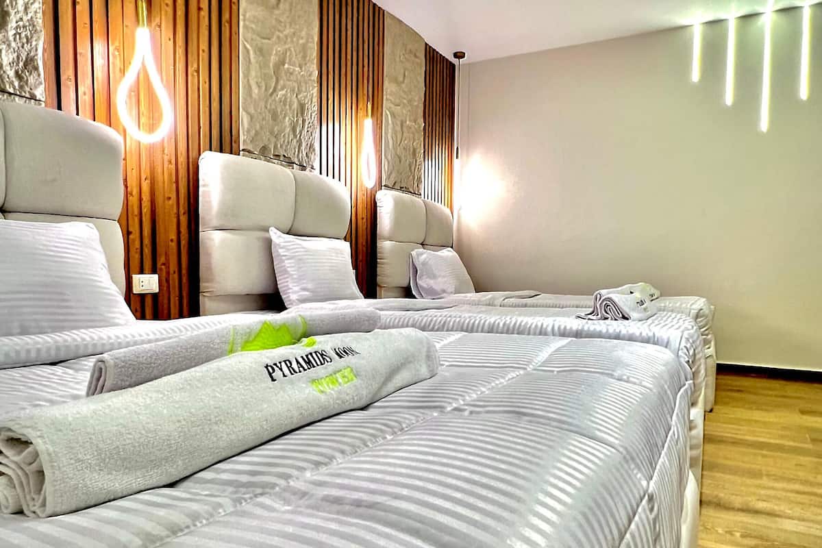Una habitación de hotel moderna con una cama grande, dos mesitas de noche y una pared de paneles de madera.
