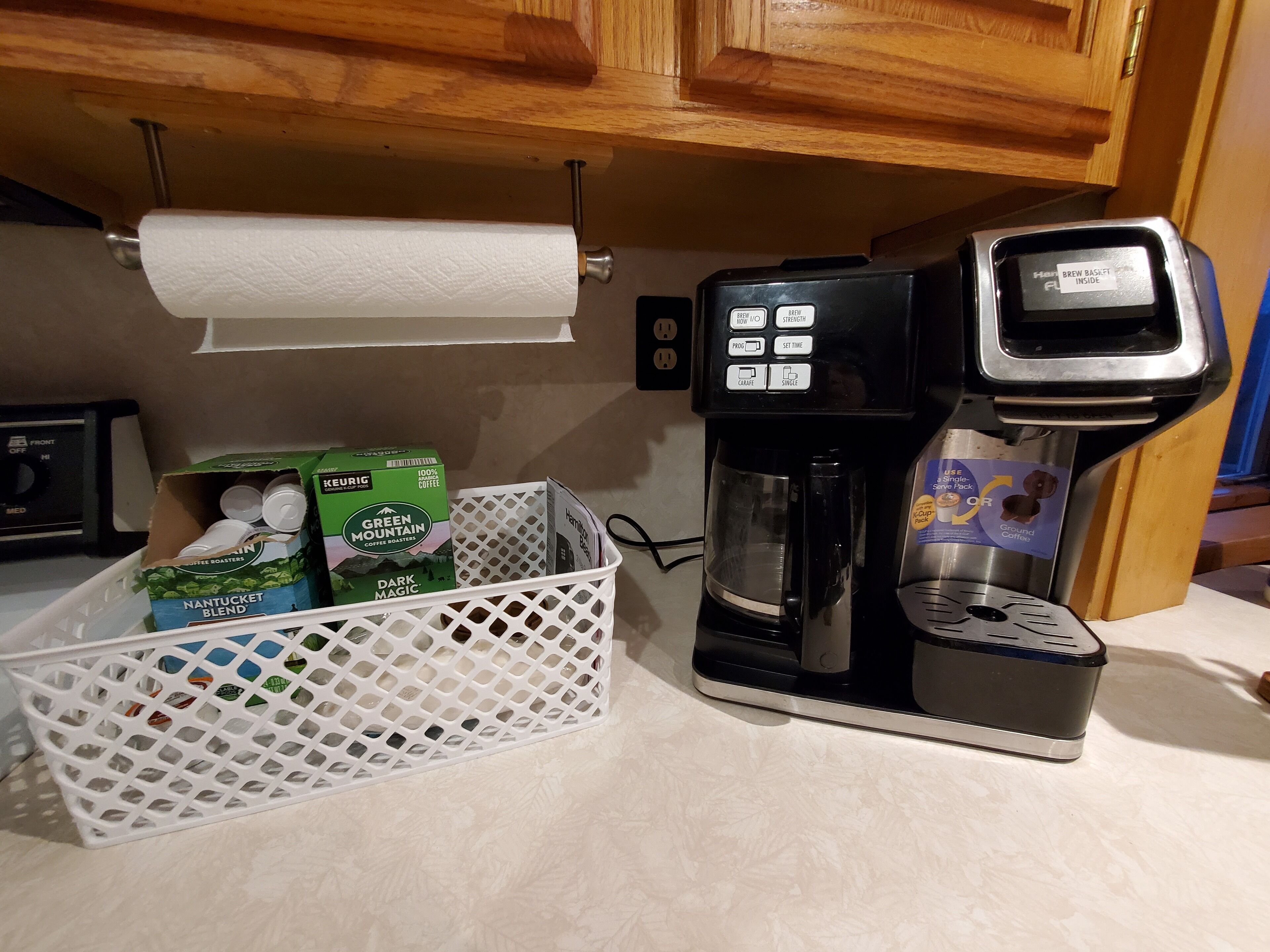 Máquina de café com coletor de borra, cesto de cápsulas de café e dispensador de papel toalha.