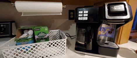 Máquina de café com coletor de borra, cesto de cápsulas de café e dispensador de papel toalha.