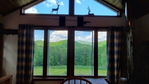 A room with a large window overlooking a forested landscape. - "Pleasant Brook Cottage" near Roxbury Village - Woods, Streams, Wi-fi, sleeps 6 (Roxbury)