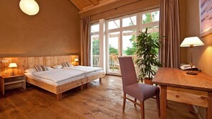 A wooden-floored room with two beds, a desk, and a chair. - Bio- und Gesundheitshotel Gutshaus Parin (Damshagen)