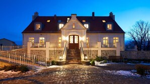 A large, two-story house with a stone facade, a central entrance with a staircase, and multiple windows. - Bio- und Gesundheitshotel Gutshaus Parin (Damshagen)