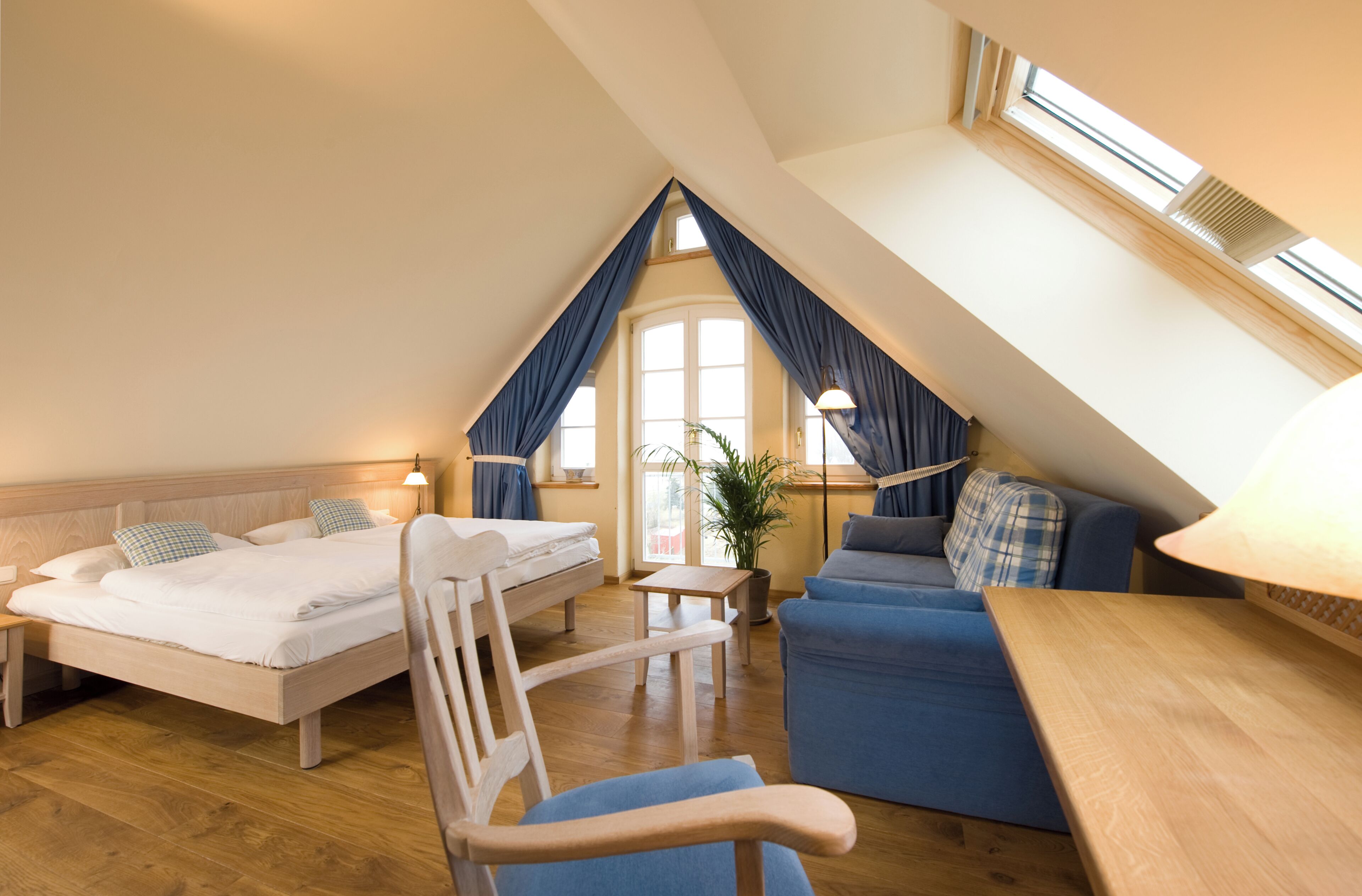A cozy room with a loft bed, a sofa, and a dining table.