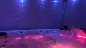 A hot tub with water jets and a plastic cover.