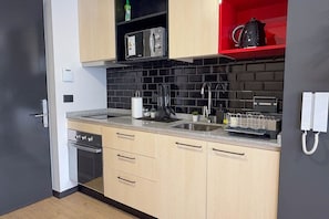 Eenvoudig appartement | Privékeuken | Een koelkast met diepvriezer, een microgolfoven, een oven, een kookplaat