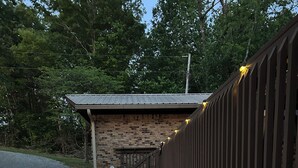 Ein Weg, der zu einem Gebäude mit einer Steinaußenseite und einer Holzterrasse führt.