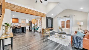 A spacious living area with a wooden ceiling, a dining area, and a kitchen in the background. - Modern Luxe 5 BR  4 BA home. Near the  Airport and Downtown Atlanta (Atlanta)