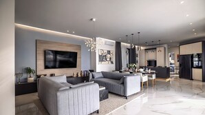 A modern living room with a grey sofa set, a flat-screen TV, and a dining area with a table and chairs. - Casa Q by Istra Vacation (Sveti Petar u Šumi)