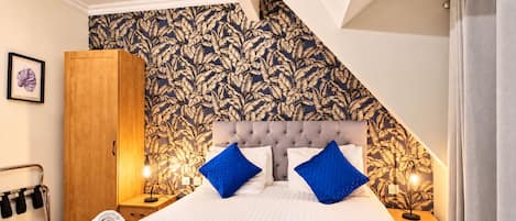 Ein Schlafzimmer mit einem Bett, zwei Nachttischen, einem Kleiderschrank und einer Kandelaber.