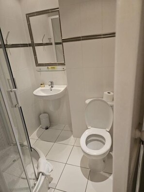 Un baño pequeño con inodoro, lavamanos y espejo.