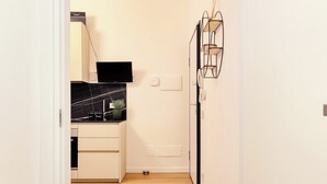A compact kitchen with a black countertop, a small plant, and a white cabinet.
