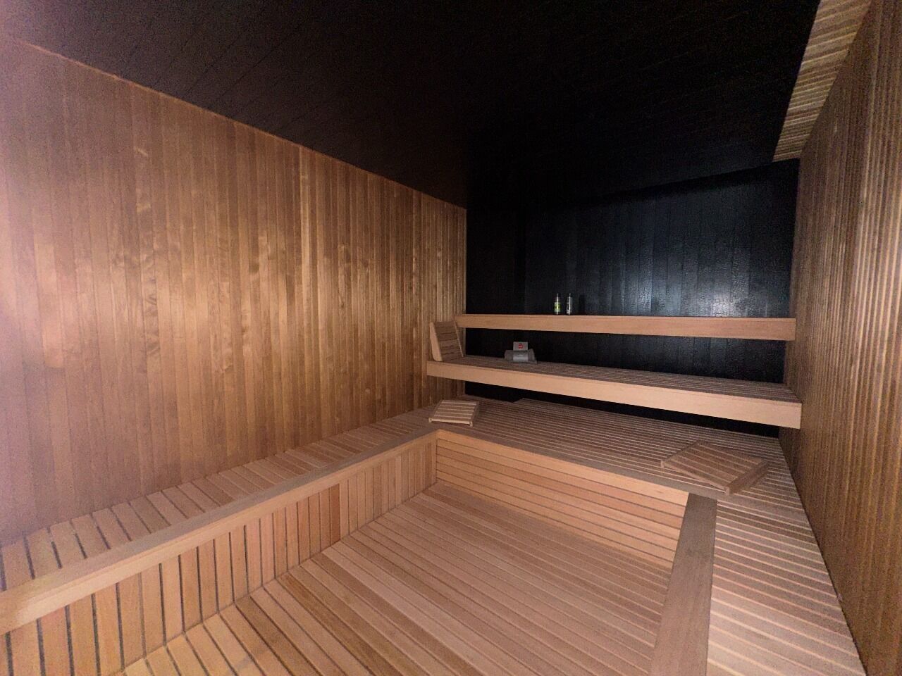 A sauna room with wooden walls and benches.