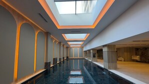 Um corredor amplo com piso de mármore refletivo, claraboias e design arquitetônico moderno.