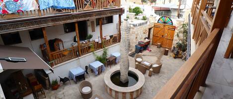 Un patio con mobiliario exterior, un pozo de piedra y una verja de madera.