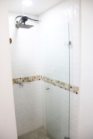 Een douche, handdoeken, zeep, toiletpapier