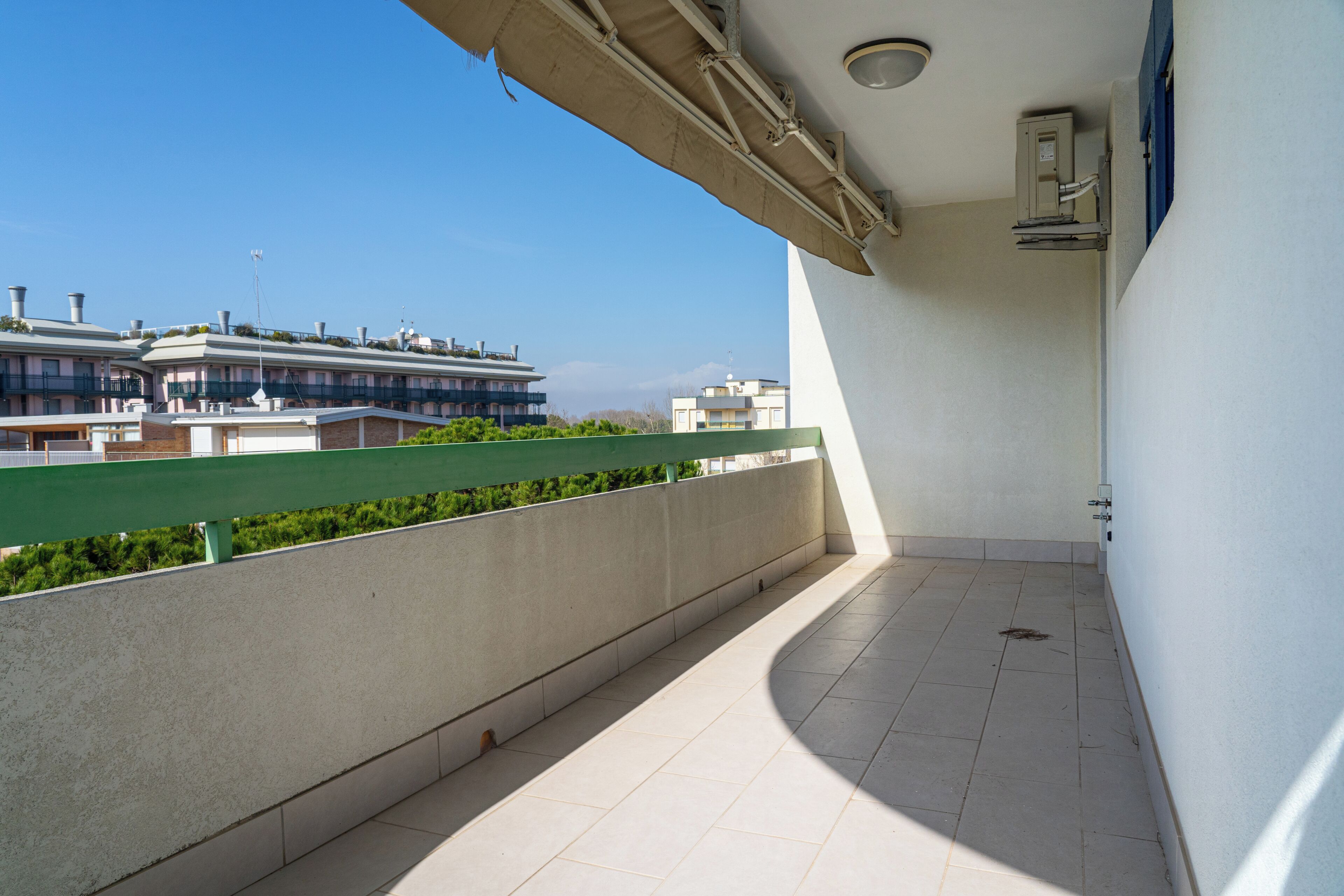 A balcony with a view of buildings in the background.