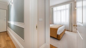 A hotel room with a bed, a window with curtains, and a door with a light switch. - GuestReady - Downtown City Apartments - 2F (Porto)