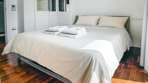 A modern bedroom with a large bed, built-in wardrobe, and a mirror. - I Ludovici Luxury B&B (Casoria)