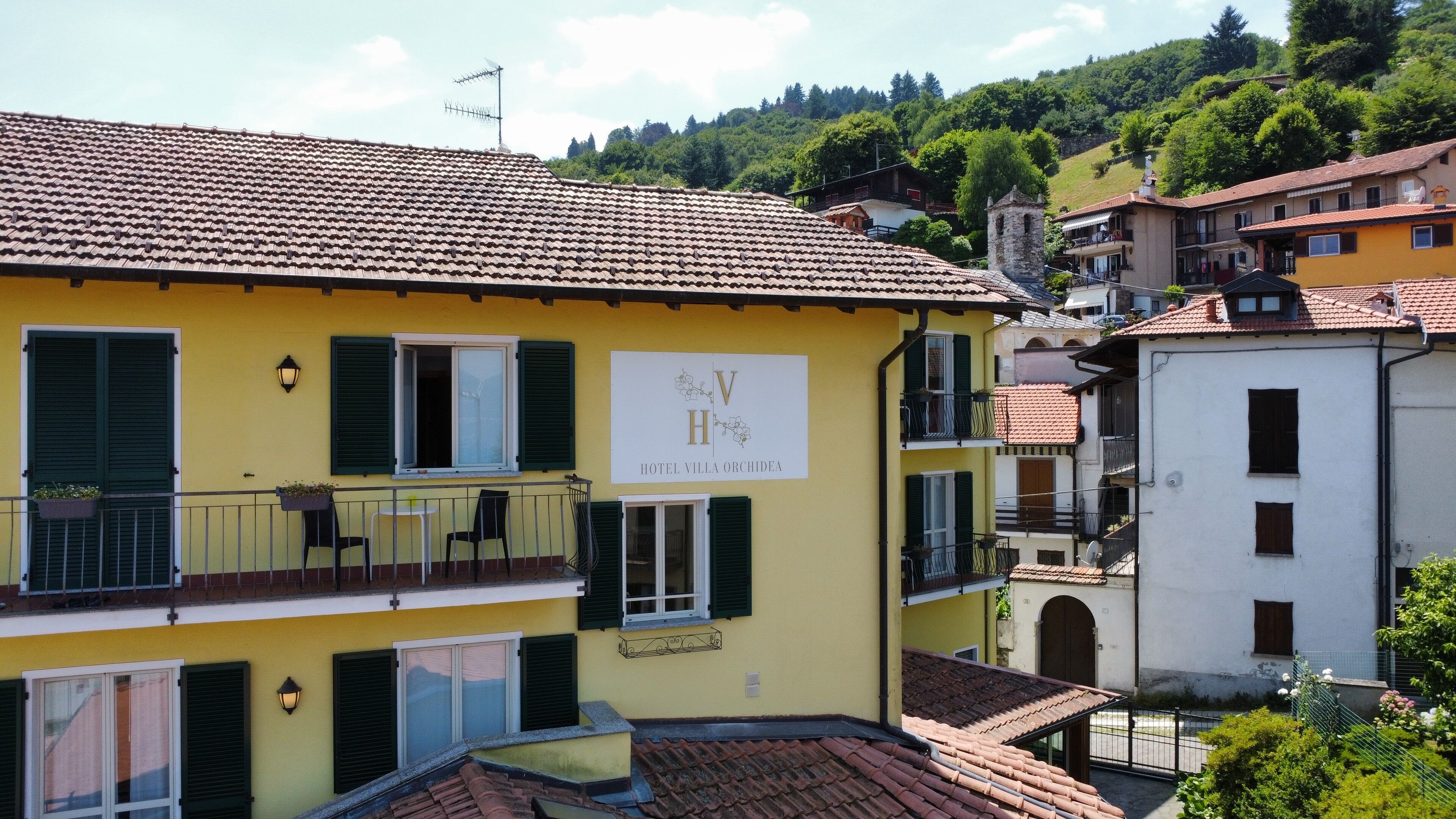 A yellow building with a sign reading "Hotel Villa Orchidea."