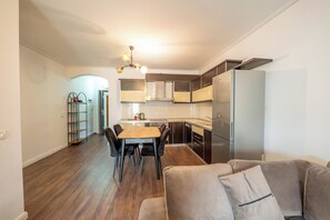 Une cuisine moderne avec un coin repas, un canapé et un luminaire suspendu au plafond.