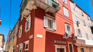 Un edifici vermell amb un rètol que diu "MARASKA" a la planta baixa.