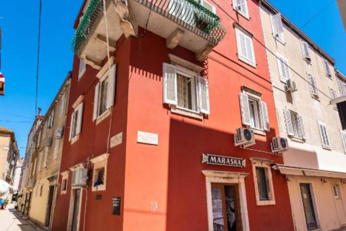 Un bâtiment rouge avec une enseigne indiquant « MARASKA » au rez-de-chaussée.