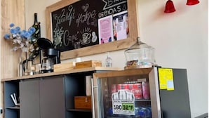 A mini bar with a chalkboard sign, a refrigerator stocked with beverages, and a wine bottle rack. - Treeloft 29 (Girón)