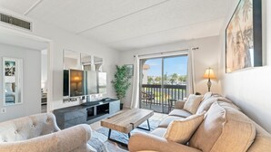 A modern living room with a sofa, armchairs, a coffee table, and a TV.