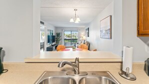 A modern kitchen with a stainless steel sink, a two-burner stove, and a countertop.