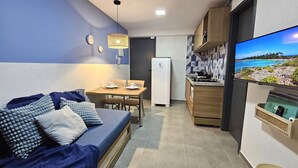 Ein kompakter Wohnbereich mit Sofa, Esstisch und Küchenzeile.