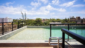 Ein Pool auf dem Dach mit freiem Blick auf die umliegenden Gebäude und Bäume.