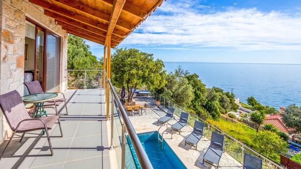 A balcony with a pool, lounge chairs, and a table. - Sunset Vista Exclusive villa (Zakynthos)