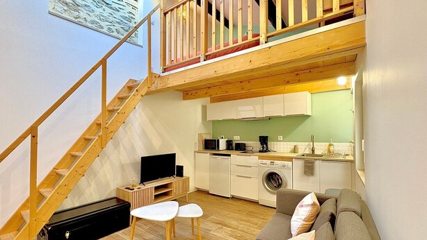 A compact living space with a loft bedroom, a kitchenette, and a seating area with a sofa and two chairs. - Le Studio des Tilleuls, Air-Conditioned & Real Bed (Nîmes)