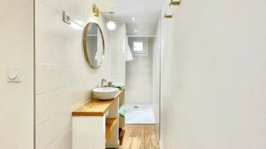 A modern bathroom with a wooden vanity, a round mirror, and a shower area. - Le Studio des Tilleuls, Air-Conditioned & Real Bed (Nîmes)